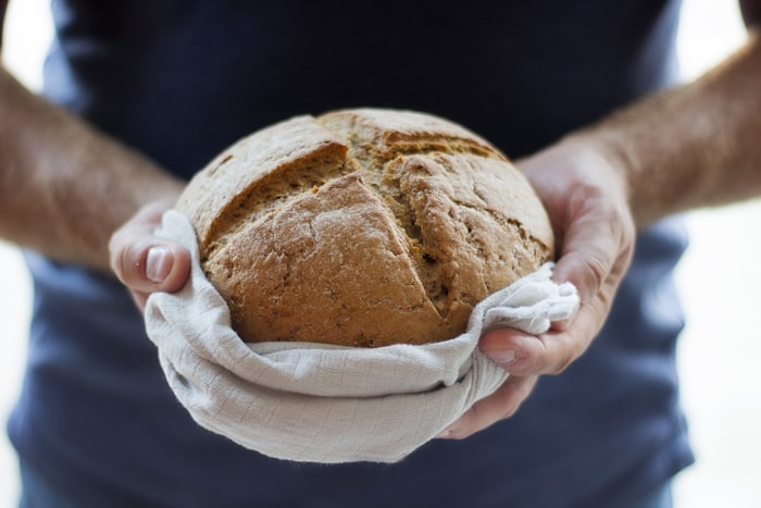 Round rye loaf held in hands